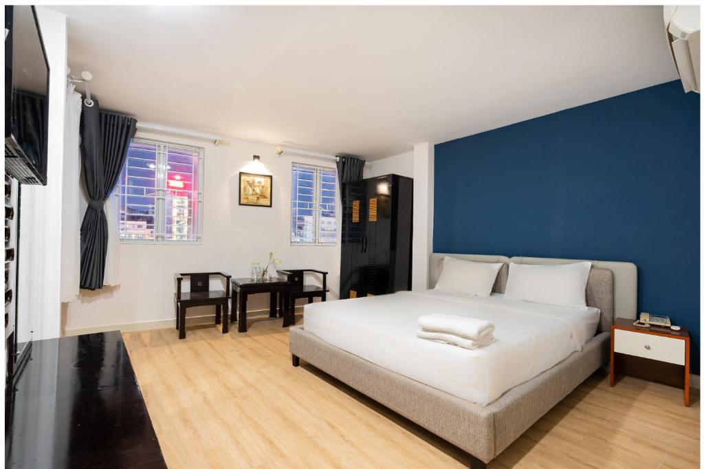 a bedroom with a white bed and a blue wall at Sen Sai Gon Hotel - Ben Thanh Market in Ho Chi Minh City