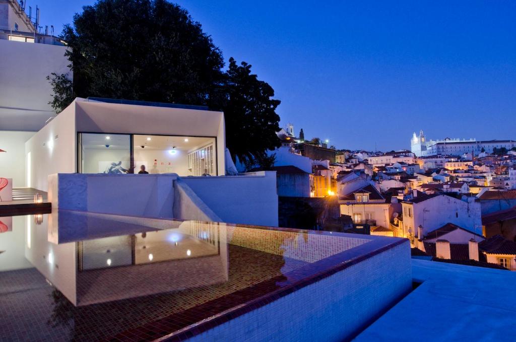 a house with a view of the city at night at Memmo Alfama - Design Hotels in Lisbon