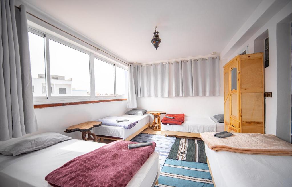 Habitación pequeña con 2 camas y sofá en Easy Going en Imsouane