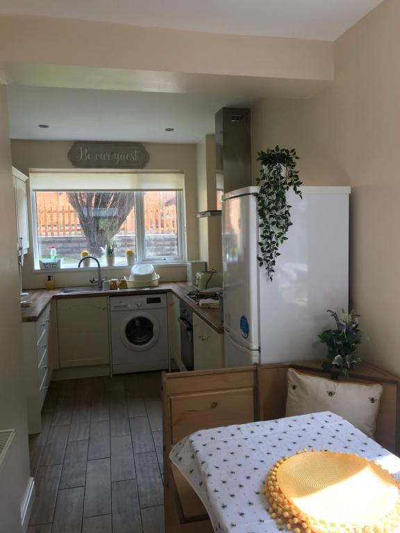 a kitchen with a refrigerator and a table in it at EXECUTIVE SINGLE & DOUBLE ROOMS - Margam, Mountain View, Nr Port Talbot Works, Hospital & Theatre in Port Talbot