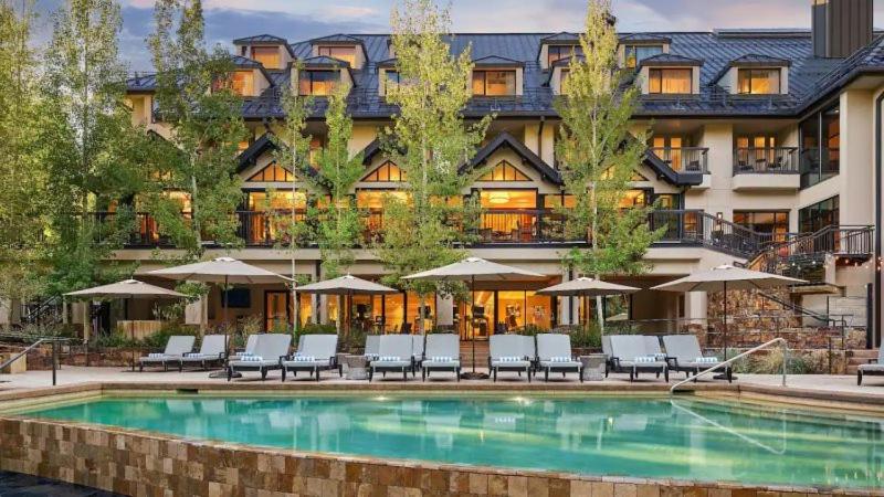 a hotel with a swimming pool in front of a building at Grand Hyatt Hotel And Condos in Vail