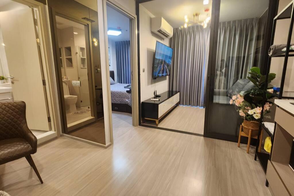 een kamer met een spiegel en een kamer met een slaapkamer bij 1 BR plus@42th FL /2-3 min walk to BTS MRT Ladprao in Bangkok