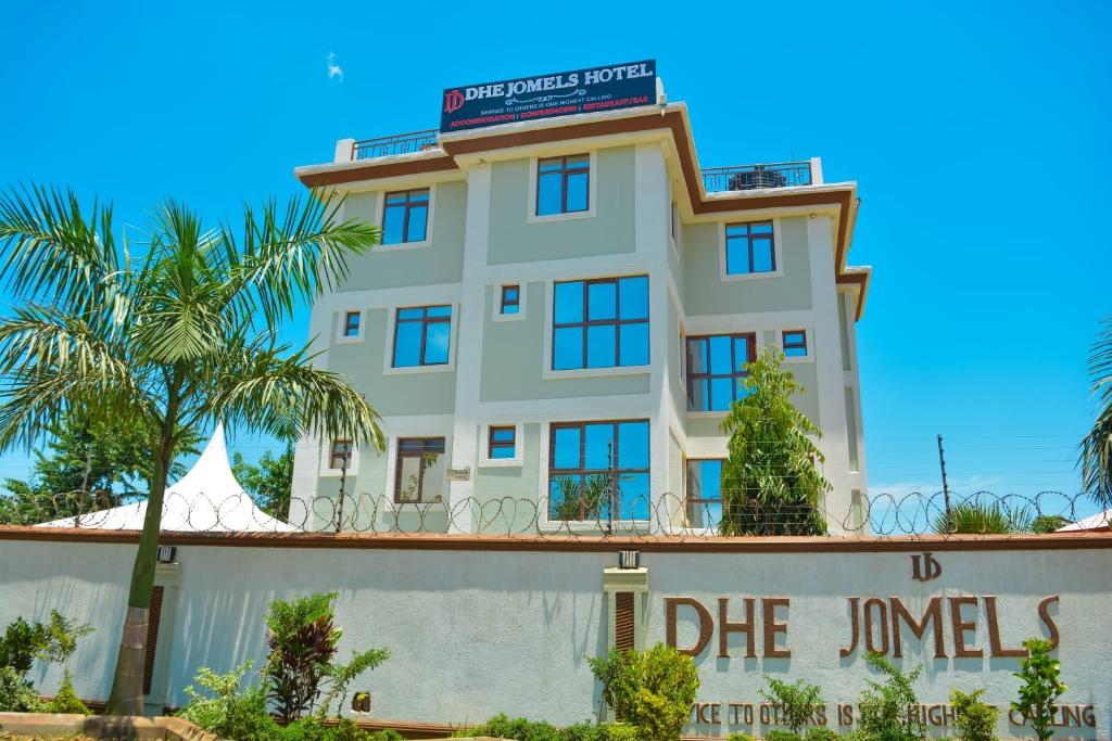 duży biały budynek z napisem w obiekcie DHE Jomels Hotel w mieście Busia