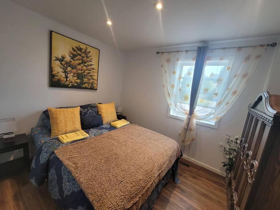 una camera con letto e finestra di Bright apartment close to hwy a Edmundston