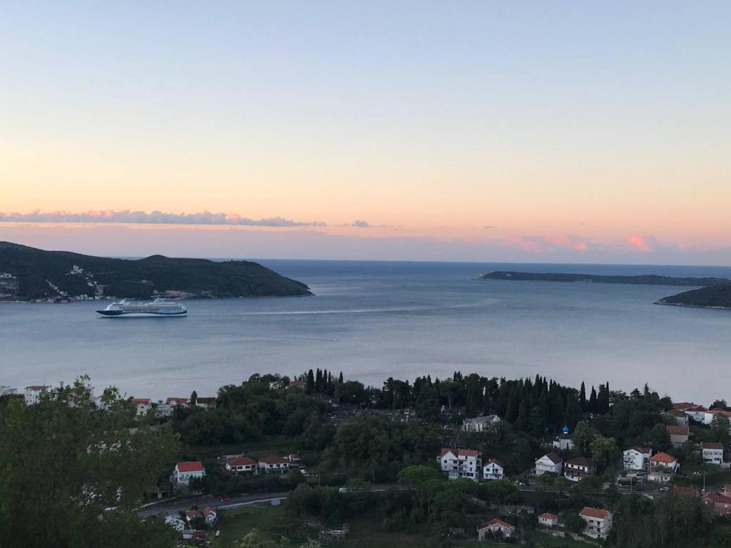 a boat in a large body of water at sunset at Apartment Nelli in Herceg-Novi
