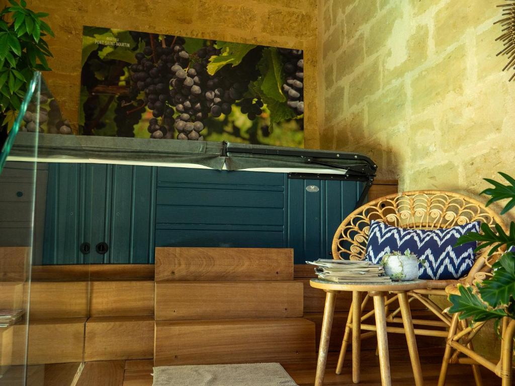 un patio con una mesa y una puerta azul en Chateau Pont Saint-Martin, en Léognan
