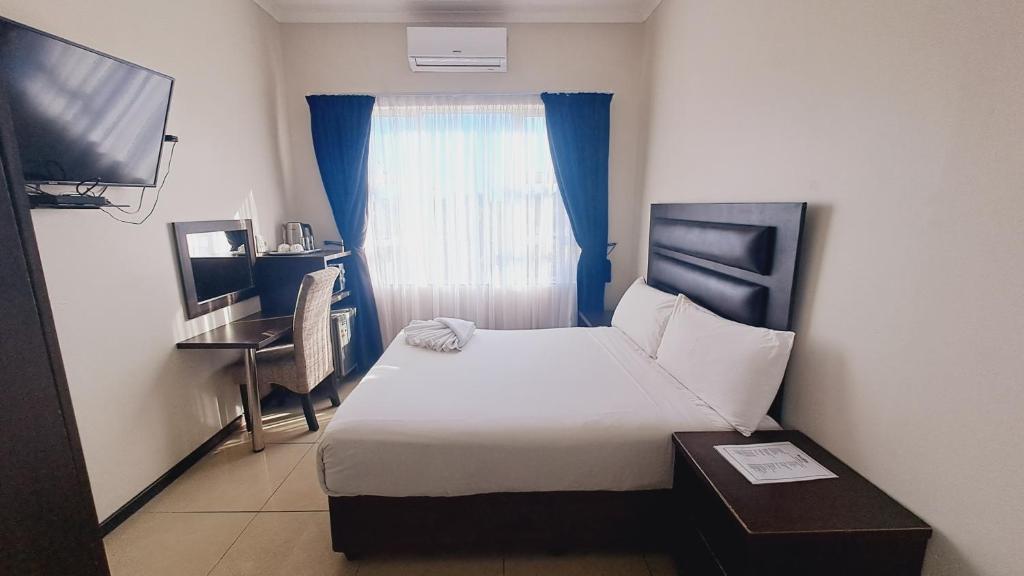 a hotel room with a bed and a window at Bayside Hotel Empangeni in Empangeni