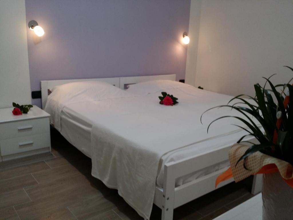 a bedroom with a white bed and a plant at Villa Felice in Porto Cesareo