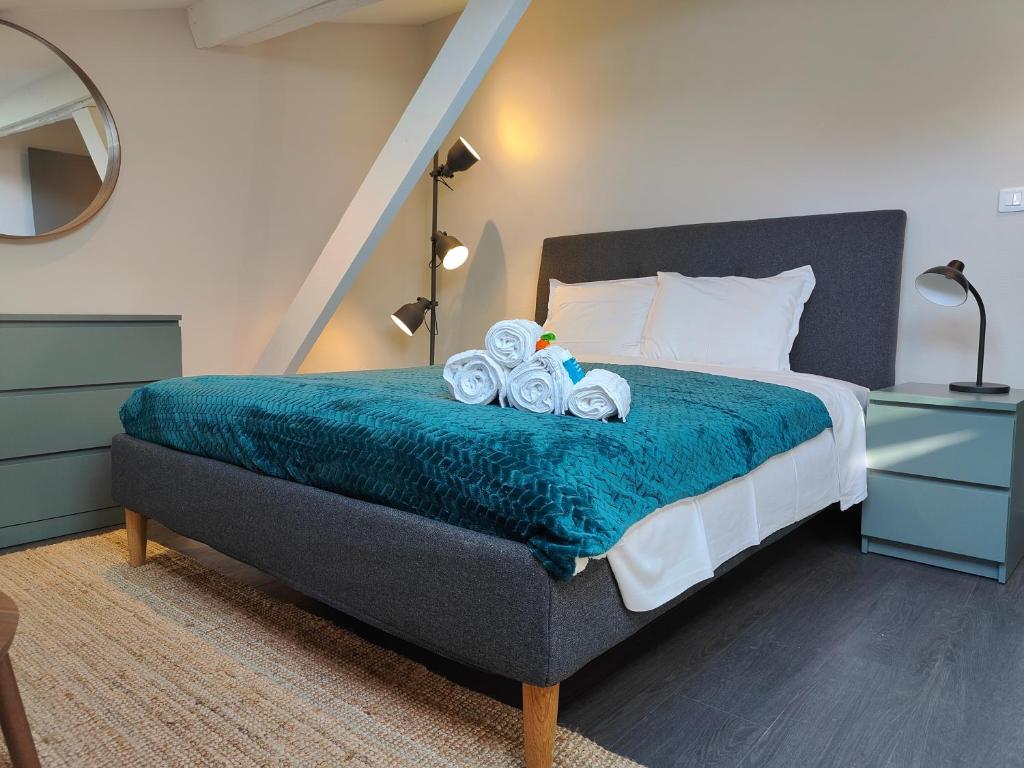 une chambre avec un lit avec une couverture bleue dans l'établissement L'Envolée - Fibre - Clim - Centre-ville, à Albi