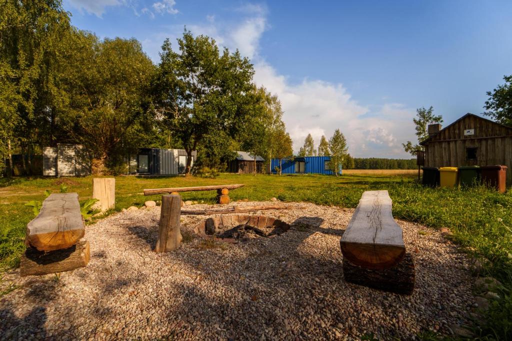 にあるArche Siedlisko Augustynka 59のピクニックテーブルと暖炉のある公園