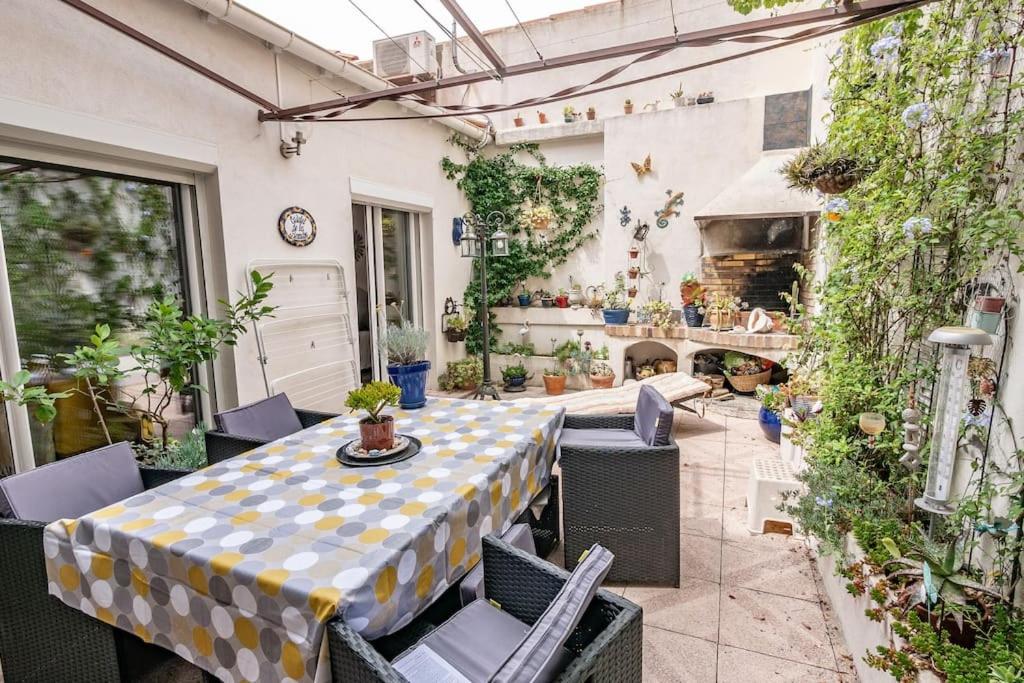 un patio avec une table, des chaises et une cheminée dans l'établissement Le maréchal, à Sète