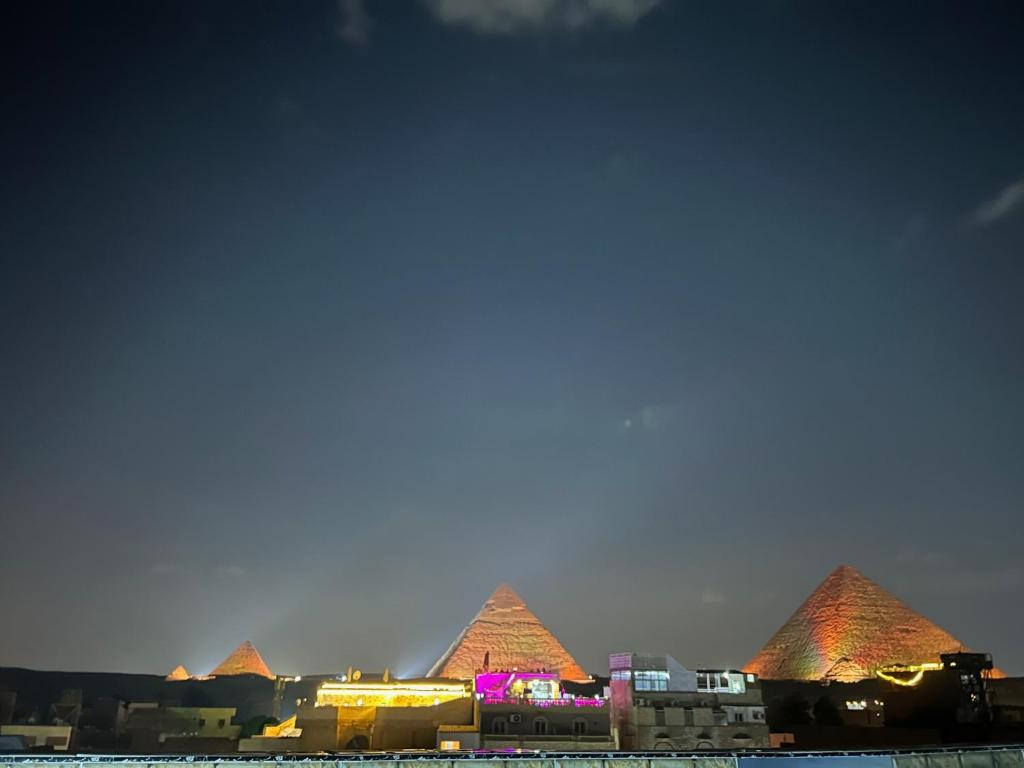 een zicht op de piramides van Giza 's nachts bij mesho falcon Pyramids view inn in Caïro