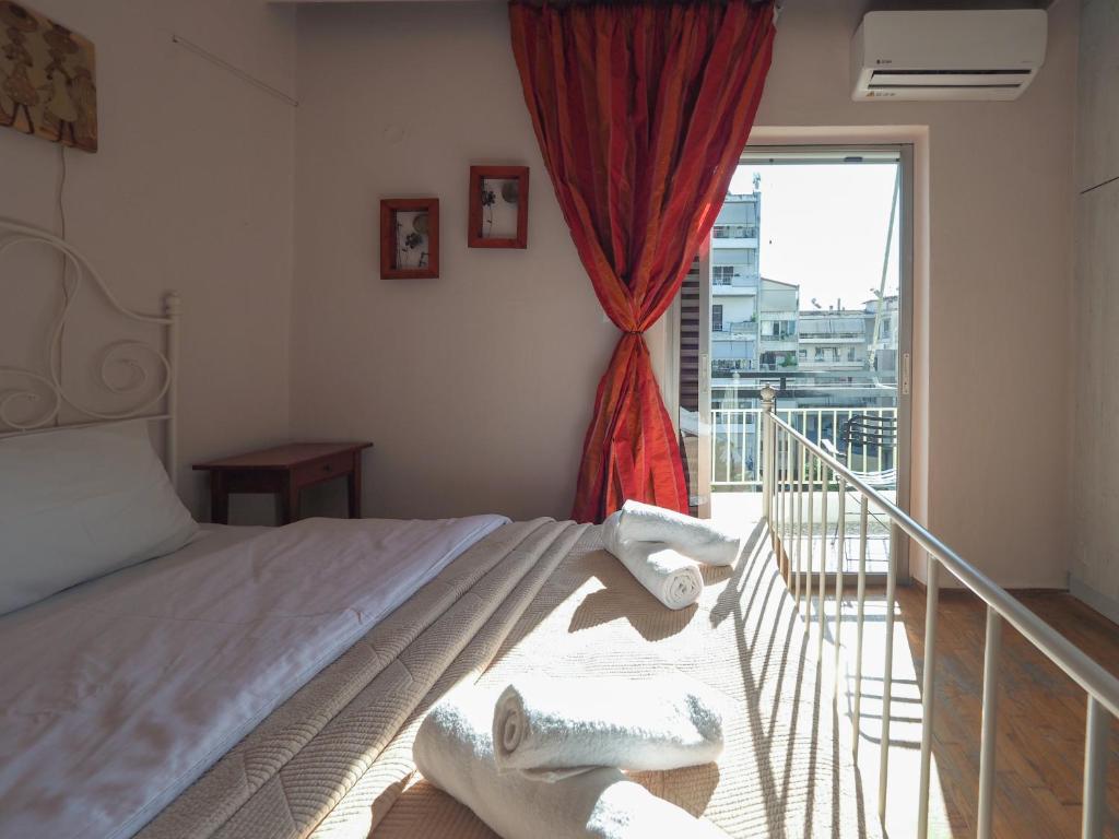 1 dormitorio con cama y ventana grande en Like HomeRetro Central Apartment, en Tríkala