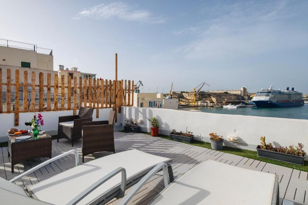 einen Balkon mit Blick auf das Wasser und ein Kreuzfahrtschiff in der Unterkunft Traditional Maltese Townhouse - Close to Sea in Senglea