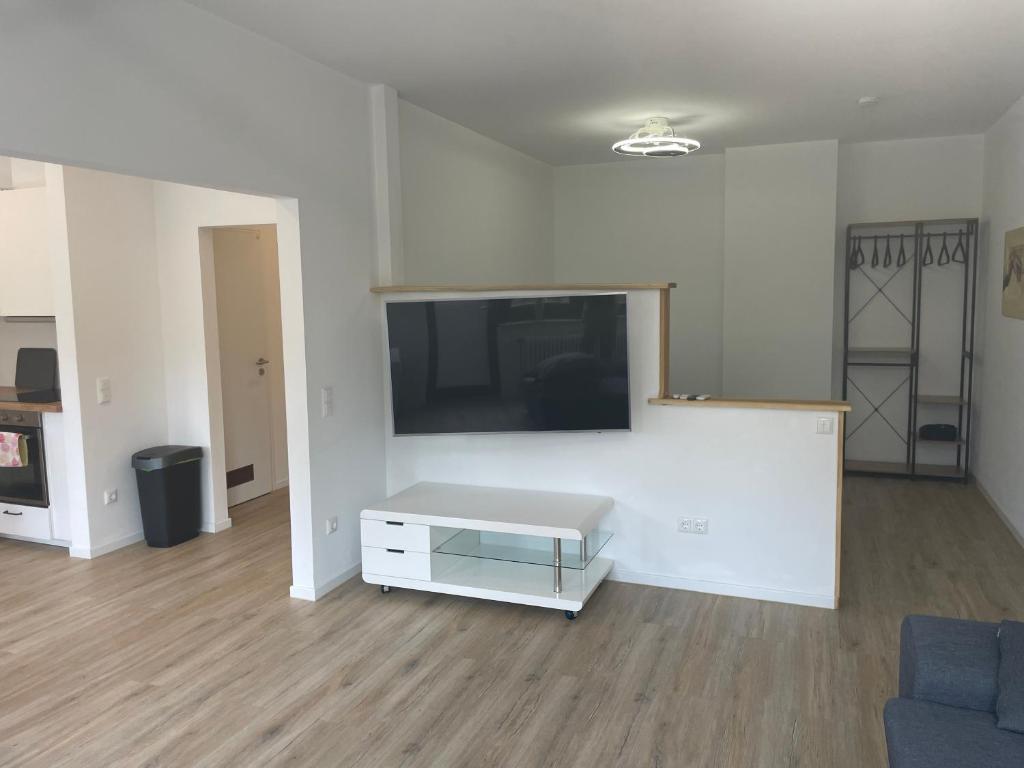 sala de estar con TV en una pared blanca en Appartment in Freizeitpark, en Wiesloch