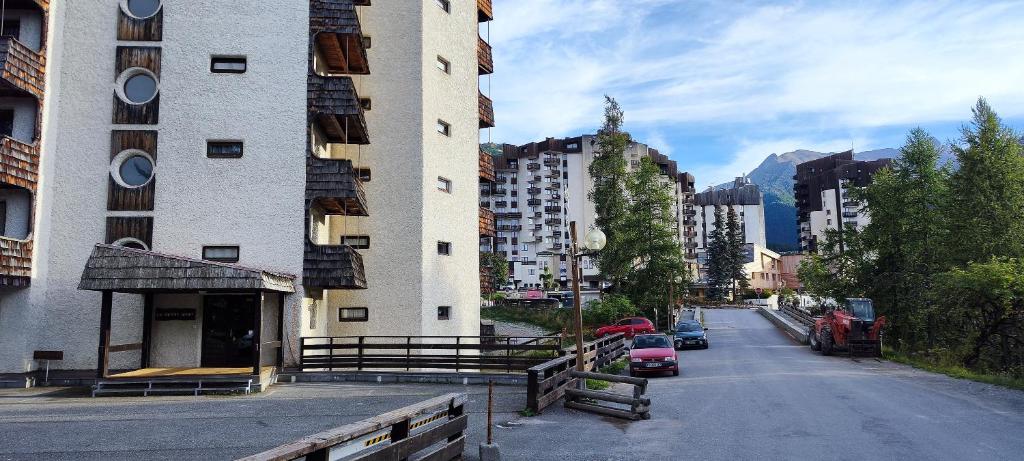 a city street with tall buildings and cars on the road at Sunny Snow Studio les Orres 1650 in Les Orres