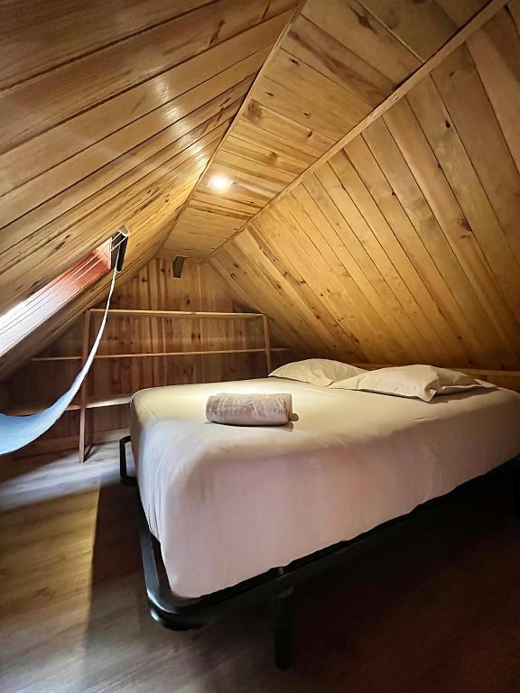 un lit dans une chambre avec un plafond en bois dans l'établissement Le petit Verdun, à Saint-Aignan