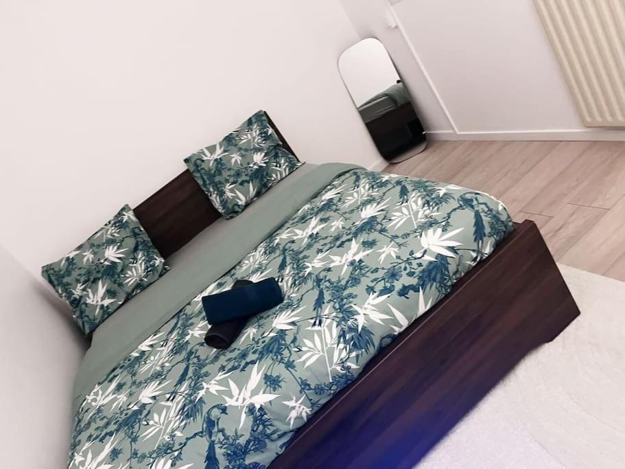 - un lit avec des draps et des oreillers bleus et blancs dans l'établissement Logement entier chambre+salon + jardin & terrasse, aux Ulis