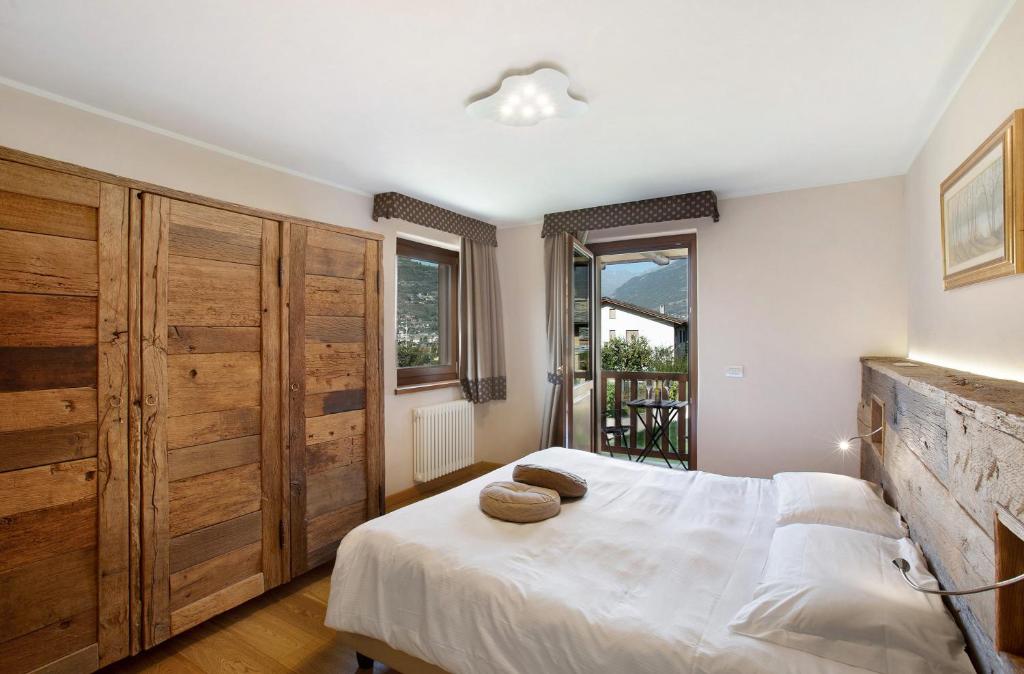 um quarto com uma grande cama branca e armários de madeira em La Vigne De Papagran App1 em Aosta