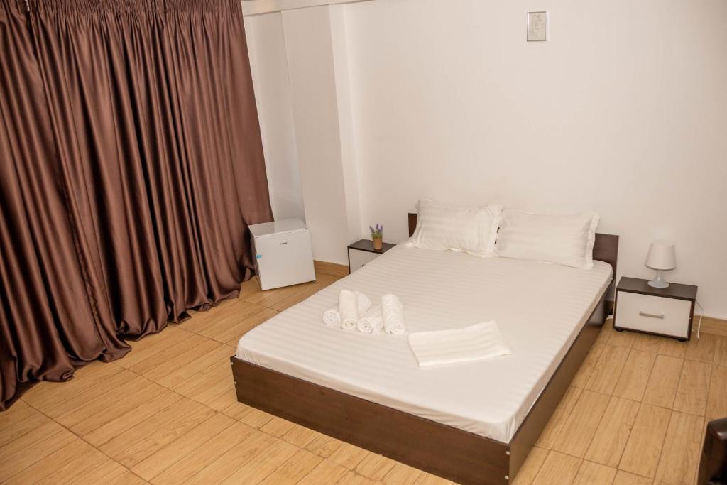 Occidental Wise Transit Hotel في بوخارست: غرفة نوم بسرير ذو شراشف ووسائد بيضاء