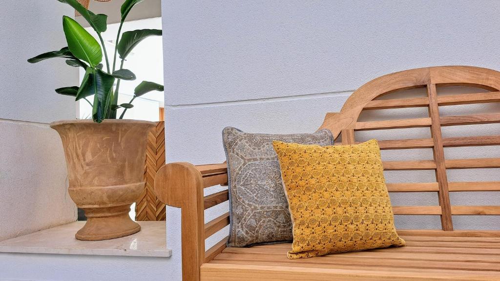 una silla de madera con un jarrón y una almohada. en Apartamentos Sherry Center, en Jerez de la Frontera