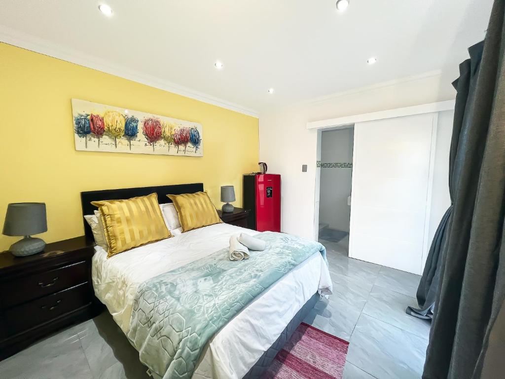 1 dormitorio con 1 cama grande y nevera roja en Boston House, en Ciudad del Cabo