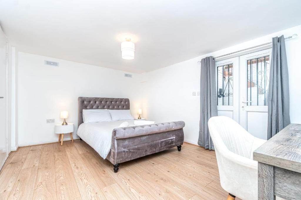 a white bedroom with a large bed and a couch at Lovely 2 Bedroom in Lower Clapton in London