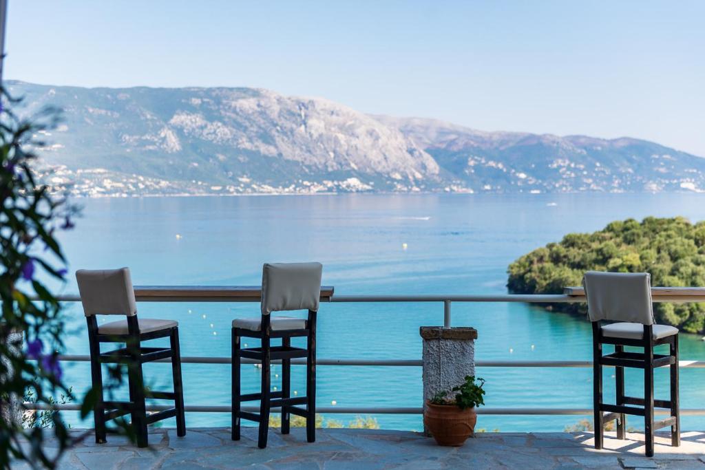 een groep stoelen op een balkon met uitzicht op een meer bij Angelos Seaview Studios by Konnect, Kommeno Corfu in Kommeno