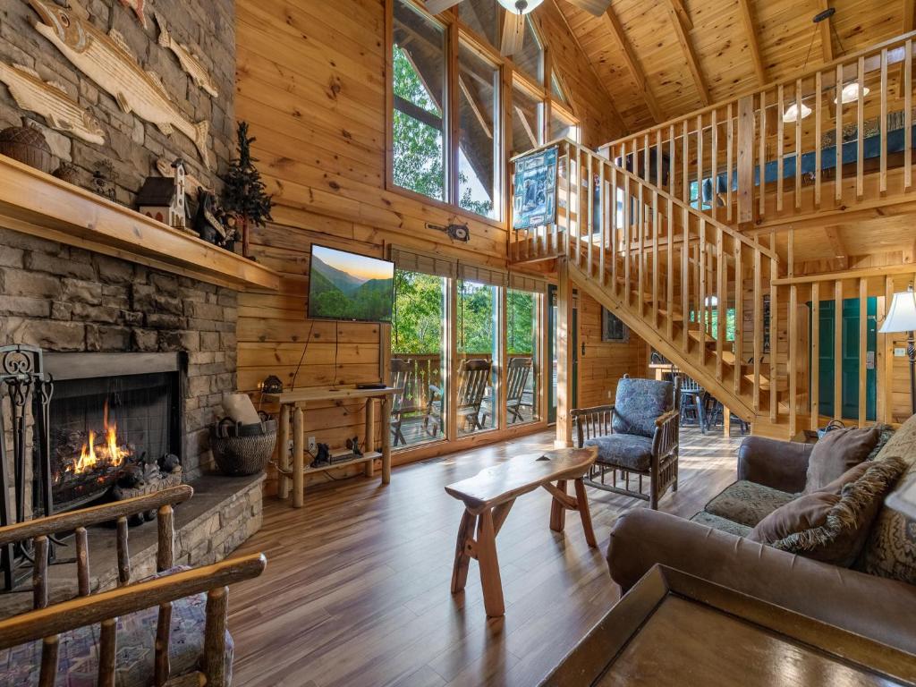 a living room with a fireplace and a stone wall at Bear Necessities, 1 Bedroom, Sleeps 8, Pool Table, Arcade, WiFi, Pets in Gatlinburg