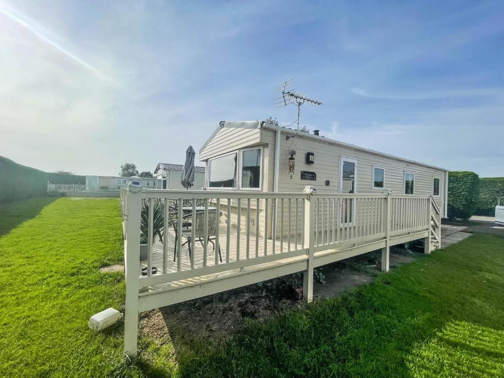 a mobile home with a porch and a fence at Caravan With Decking At Southview Holiday Park In Skegness Ref 33005s in Skegness