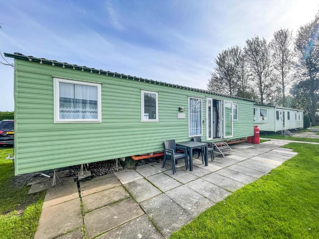 a green mobile home with a table and chairs at Lovely 8 Berth Caravan At Southview Holiday Park Near Skegness Beach Ref 33031cl in Skegness