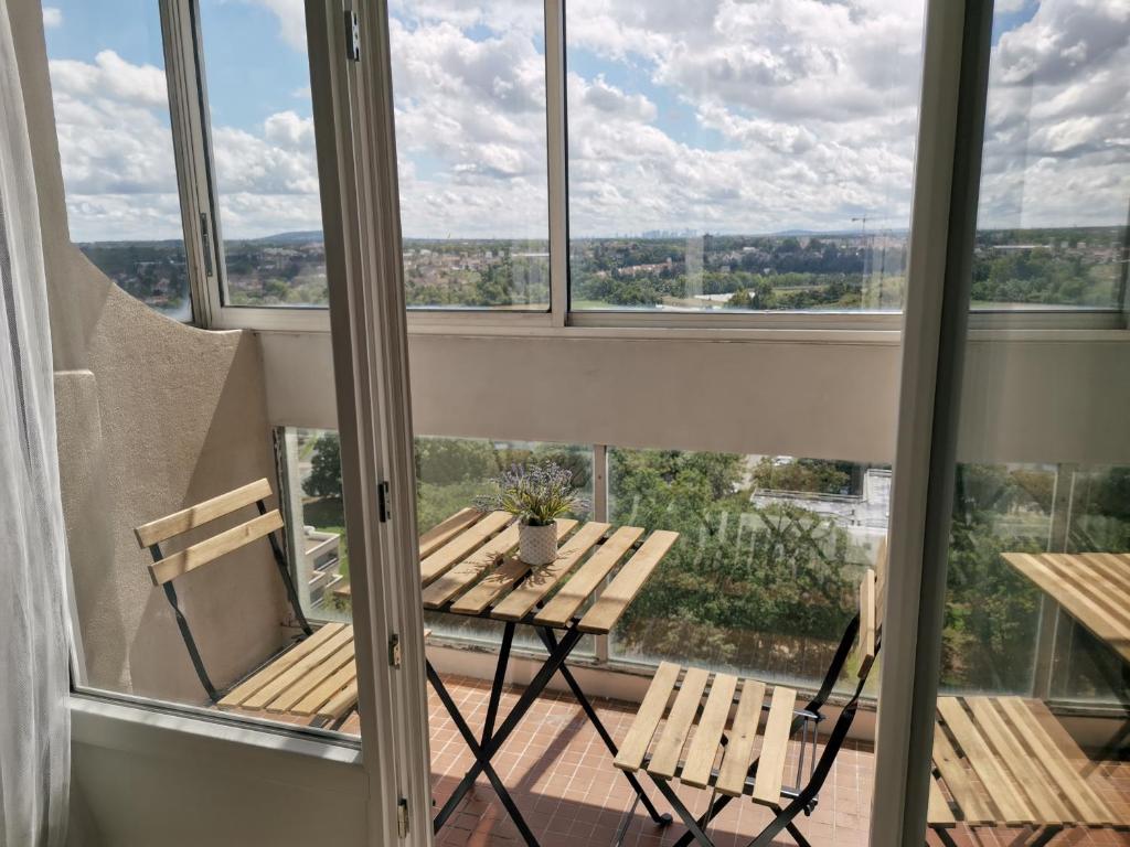 d'un balcon avec une table, des chaises et des fenêtres. dans l'établissement Grand lumineux appartement près de Paris de 4 chambres, 80 m², à Cergy