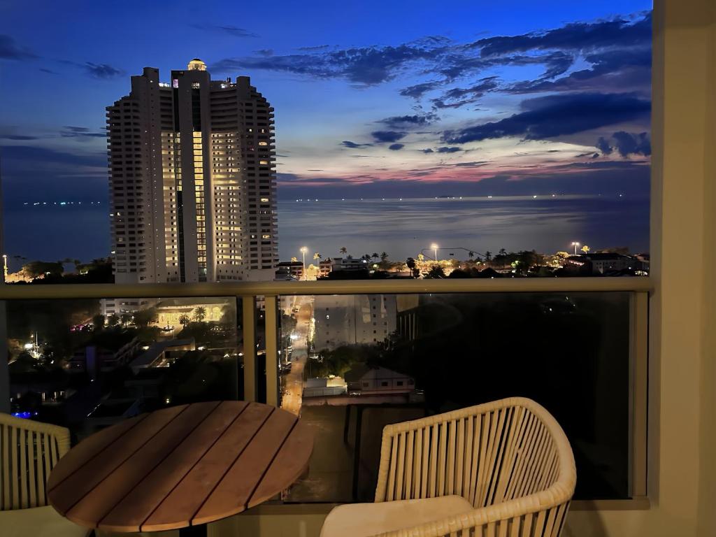 a balcony with a view of a city at night at 芭提雅高层海景奢华公寓The Riviera Jomtien生香家直达海滩3206 in Jomtien Beach
