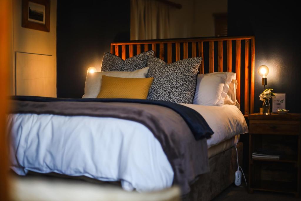 a bedroom with a large bed with many pillows at Fraaiuitsig in Kokstad