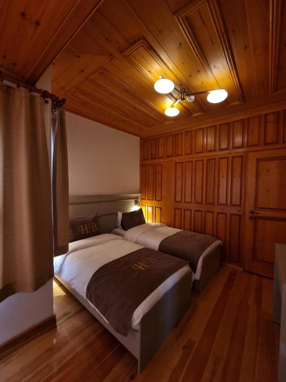 1 dormitorio con 2 camas, paredes de madera y techo en HaciBayramApart en Estambul