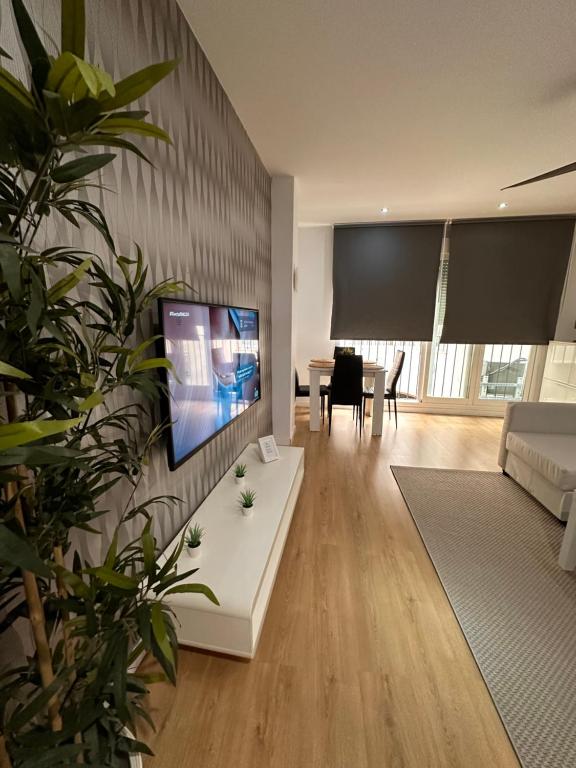 sala de estar con TV de pantalla plana en la pared en Carreteria Deluxe, en Málaga