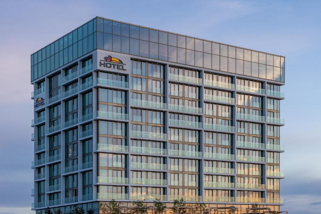 a tall glass office building with a sign on it at Van der Valk Hotel Eindhoven-Best in Best