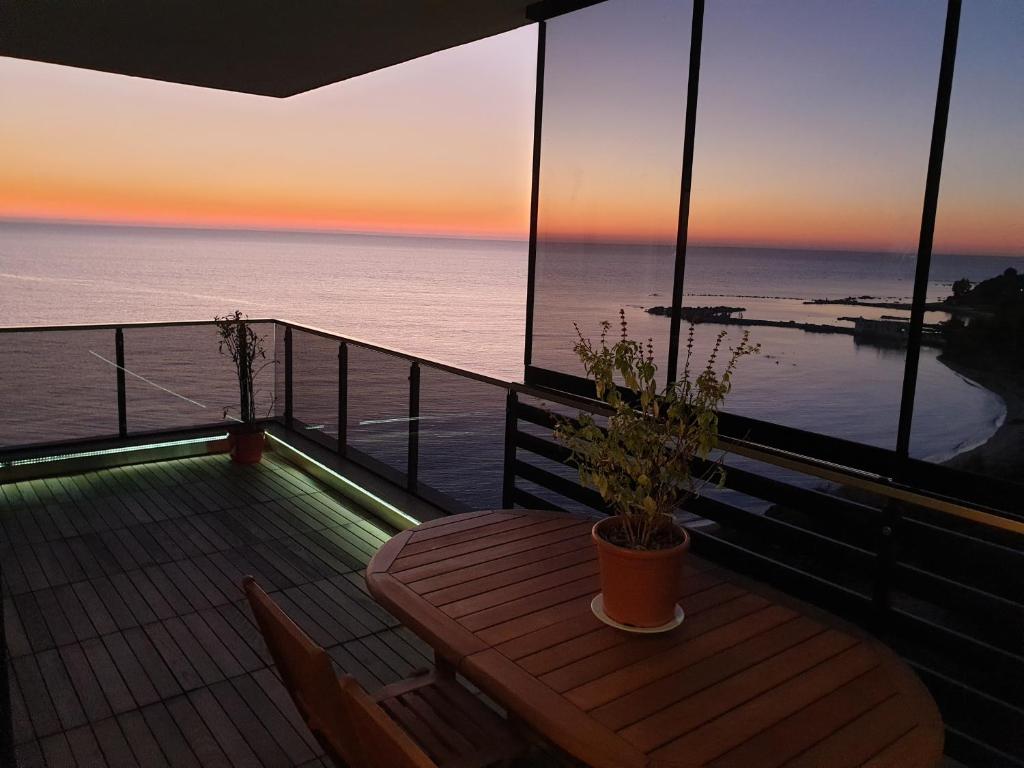uma varanda com uma mesa e vista para o oceano em SUNSET VIBES DURRËS em Durrës