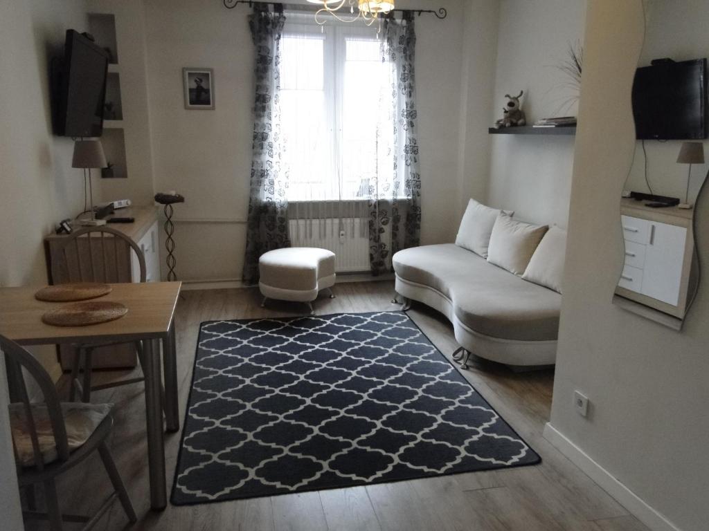 una sala de estar con un sofá y una mesa en Studio w centrum Starego Miasta, en Olsztyn