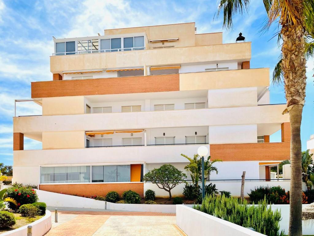 ein weißes Gebäude mit Bäumen davor in der Unterkunft Attractive apartment in Roquetas de Mar with terrace in Roquetas de Mar
