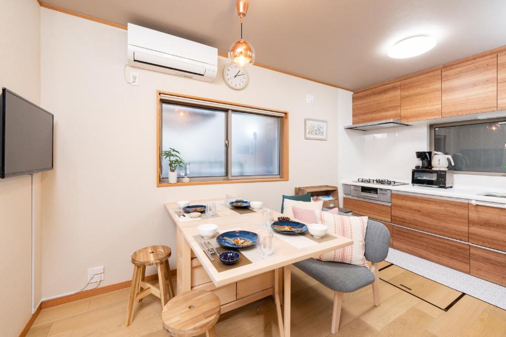 uma cozinha com mesa e cadeiras num quarto em YUKIMARU in em Tóquio