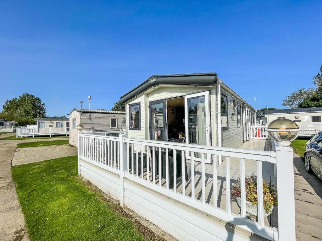 Casa móvil con porche y barandilla blanca en Gorgeous 6 Berth Caravan With Decking And Wi-fi At Broadland Sands Ref 20377bs, en Hopton on Sea