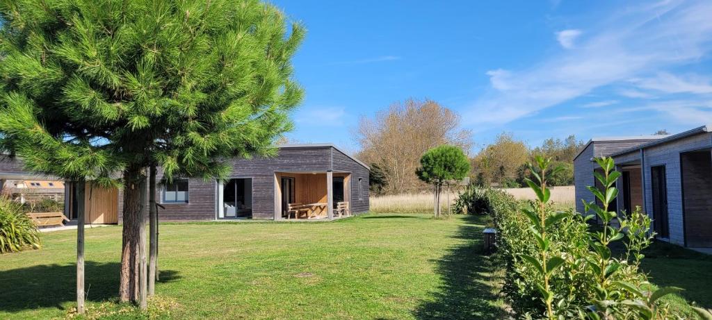 a house with a tree in the yard at Gîtes des Embruns in Agon Coutainville