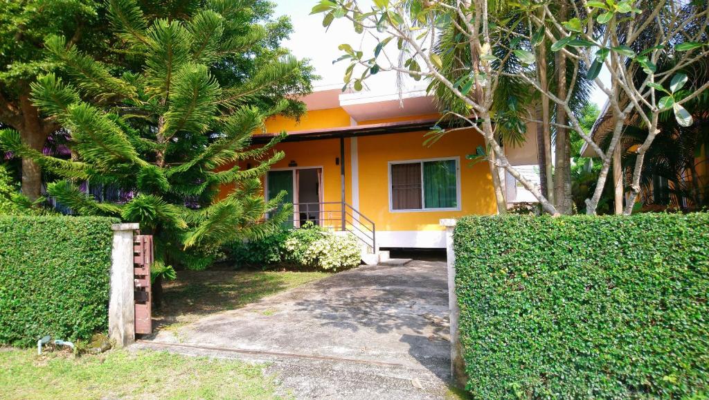 a yellow house with a fence in front of it at Little Yellow House - AoNang in Ao Nang Beach
