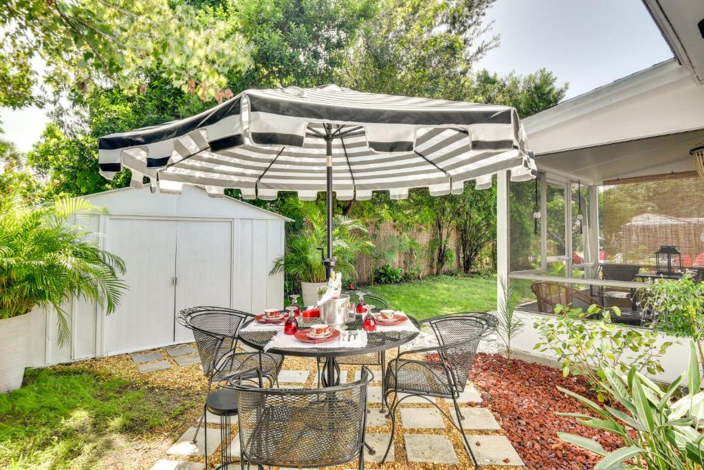 a patio with a table and chairs under an umbrella at Bright Florida Home with Patio and Grill, Near Beaches in New Smyrna Beach