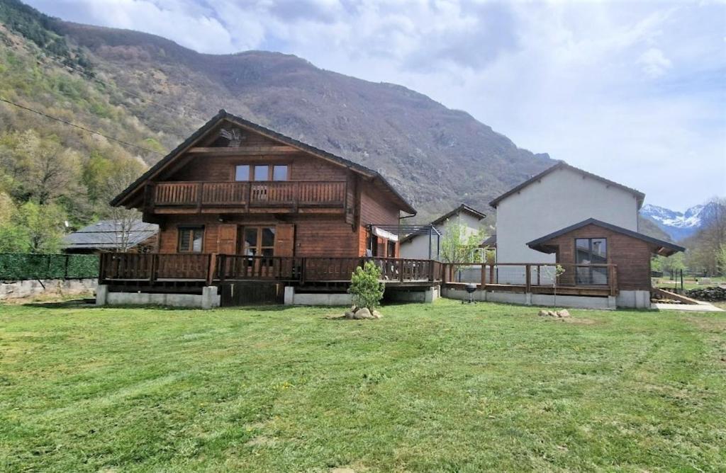a house with a large yard in front of a mountain at Chalet de 3 chambres avec jacuzzi terrasse amenagee et wifi a Orlu in Orlu