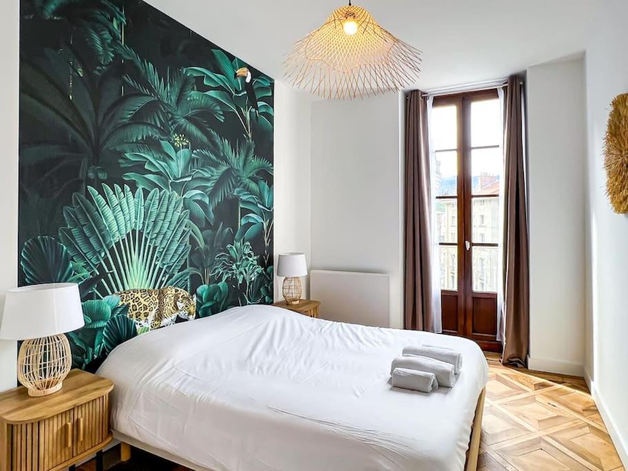 - une chambre avec un grand lit et du papier peint tropical dans l'établissement Hyper-centre de Grenoble, ambiance tropicale, wifi fibre, à Grenoble