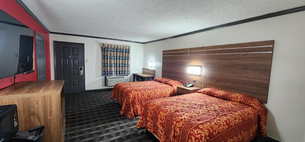 ein Hotelzimmer mit 2 Betten und einem TV in der Unterkunft Victorian Inn Midland in Midland