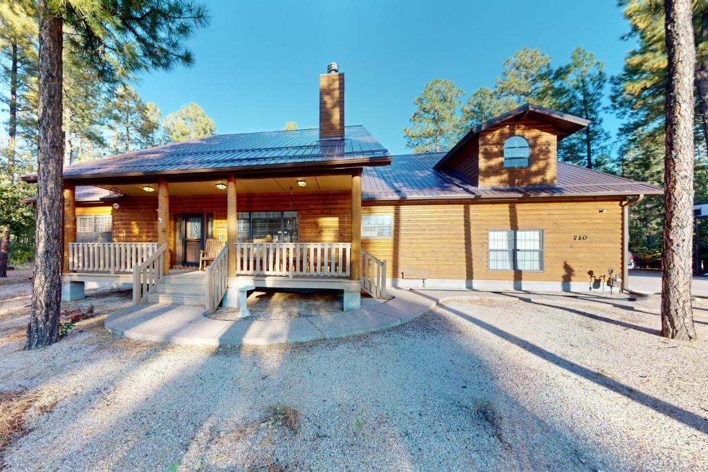 a log cabin with two benches in front of it at Osprey Cabin in Pinetop-Lakeside