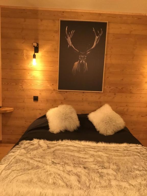 a bedroom with a bed with a picture on the wall at Studio du cerf in Megève